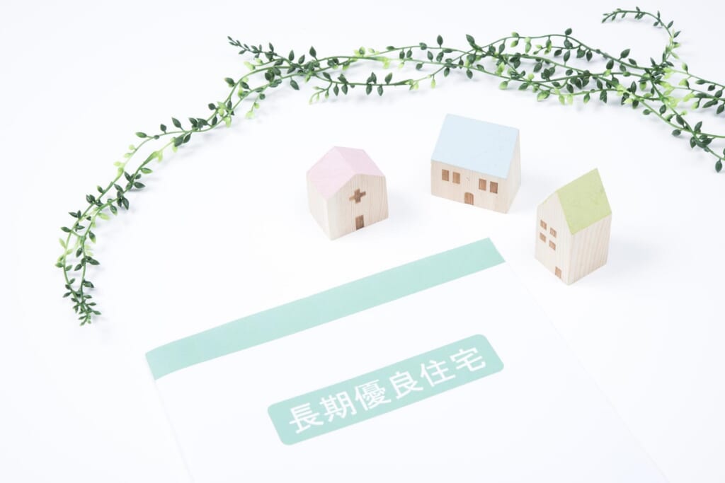 長期優良住宅と記載された書類と、おもちゃの家、植物