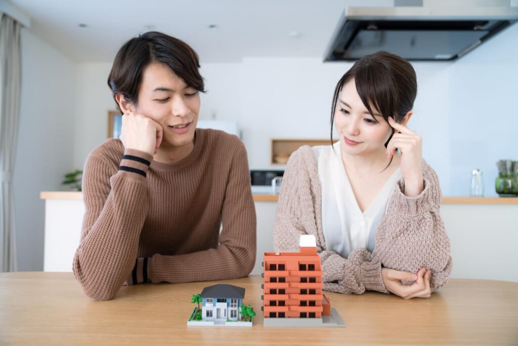 戸建てとマンションの模型を見ながら考える夫婦
