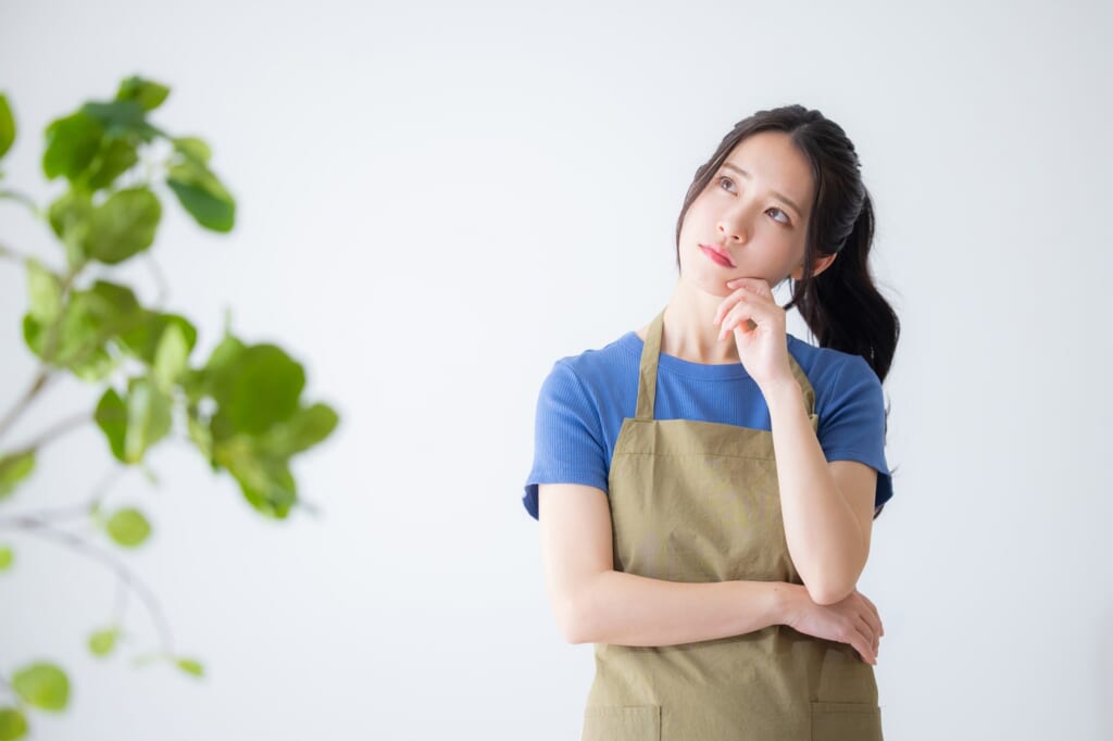 何かを考える女性、手前にグリーン