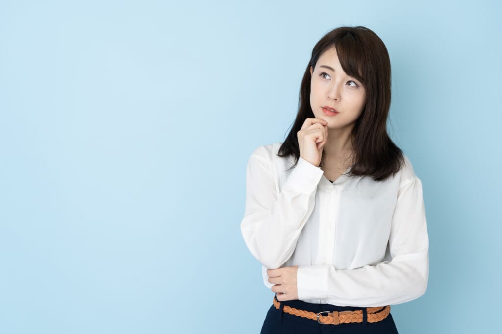 青い背景と考える女性