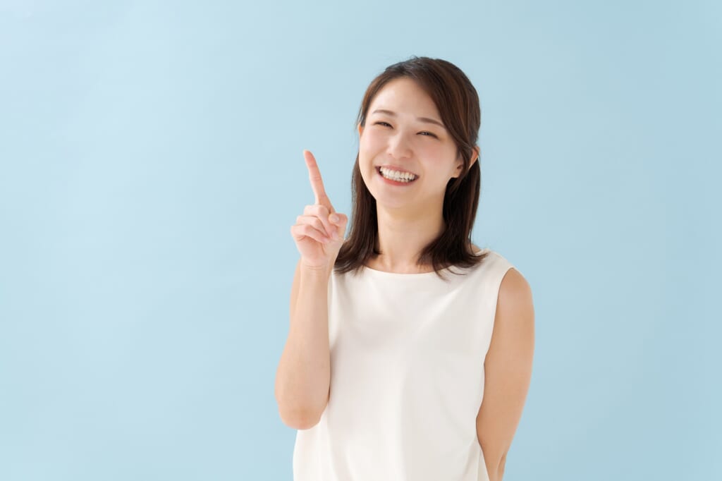 笑顔で指差しをする女性