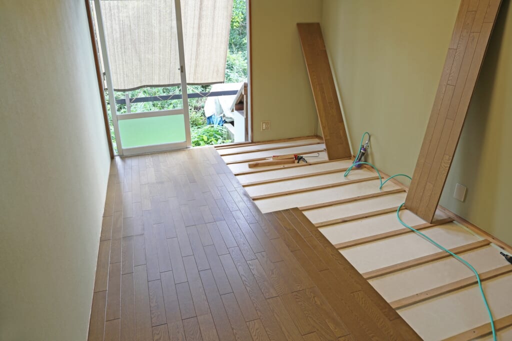 床の施工中、根太の上にフローリングを張っている様子