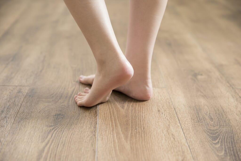 木製の床に立つ裸足