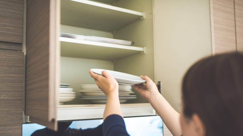 お皿を取り出す女性