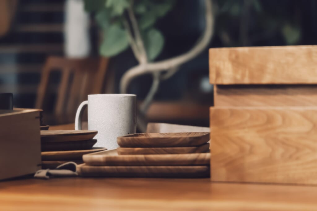 重ねられた木製のプレートや木箱、マグカップ